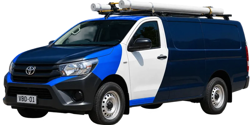 A licensed Fairfield plumbing van loaded with pipe on the roof rack